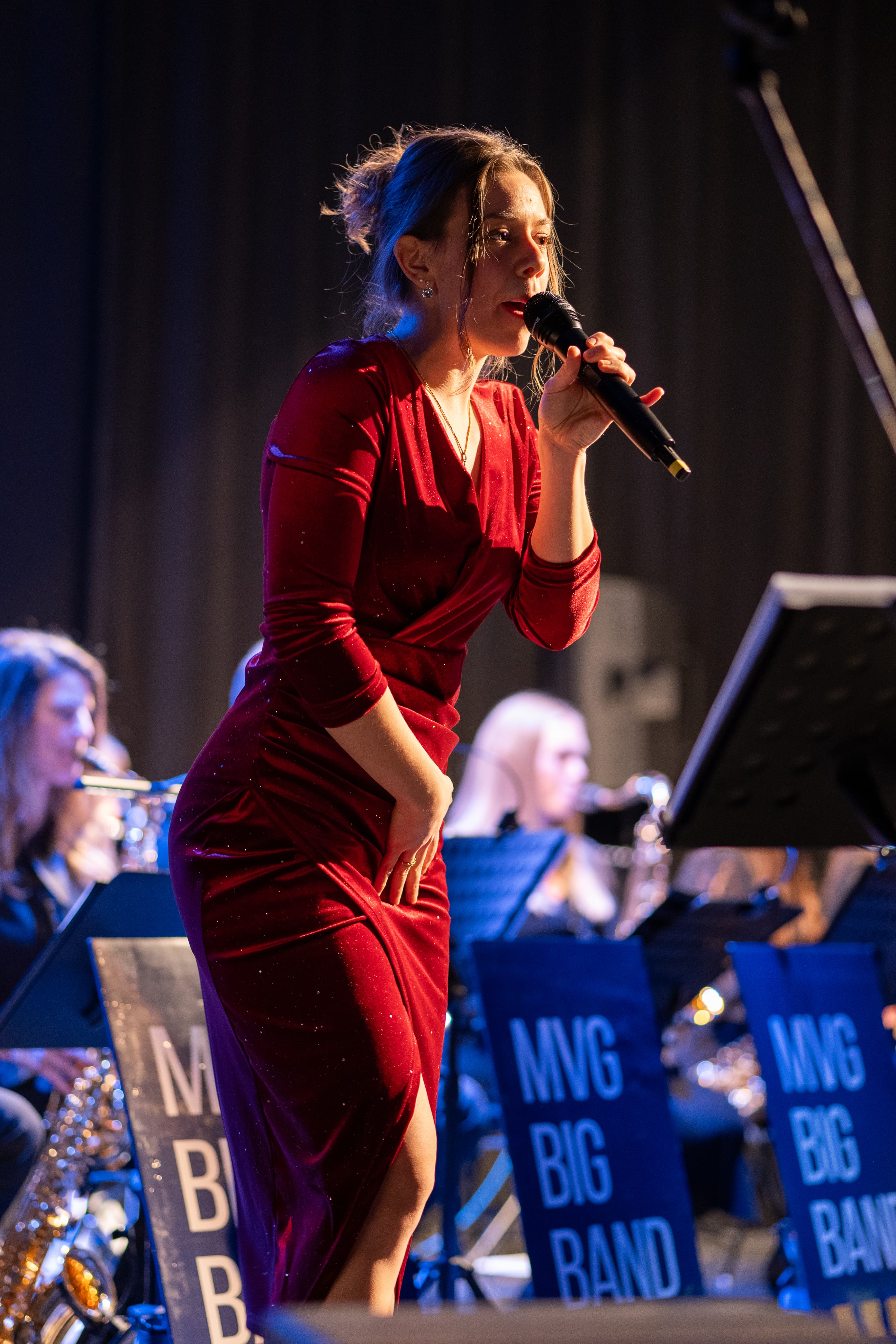Pamela singt bei einem Konzert im roten Kleid vor einer Big Band
