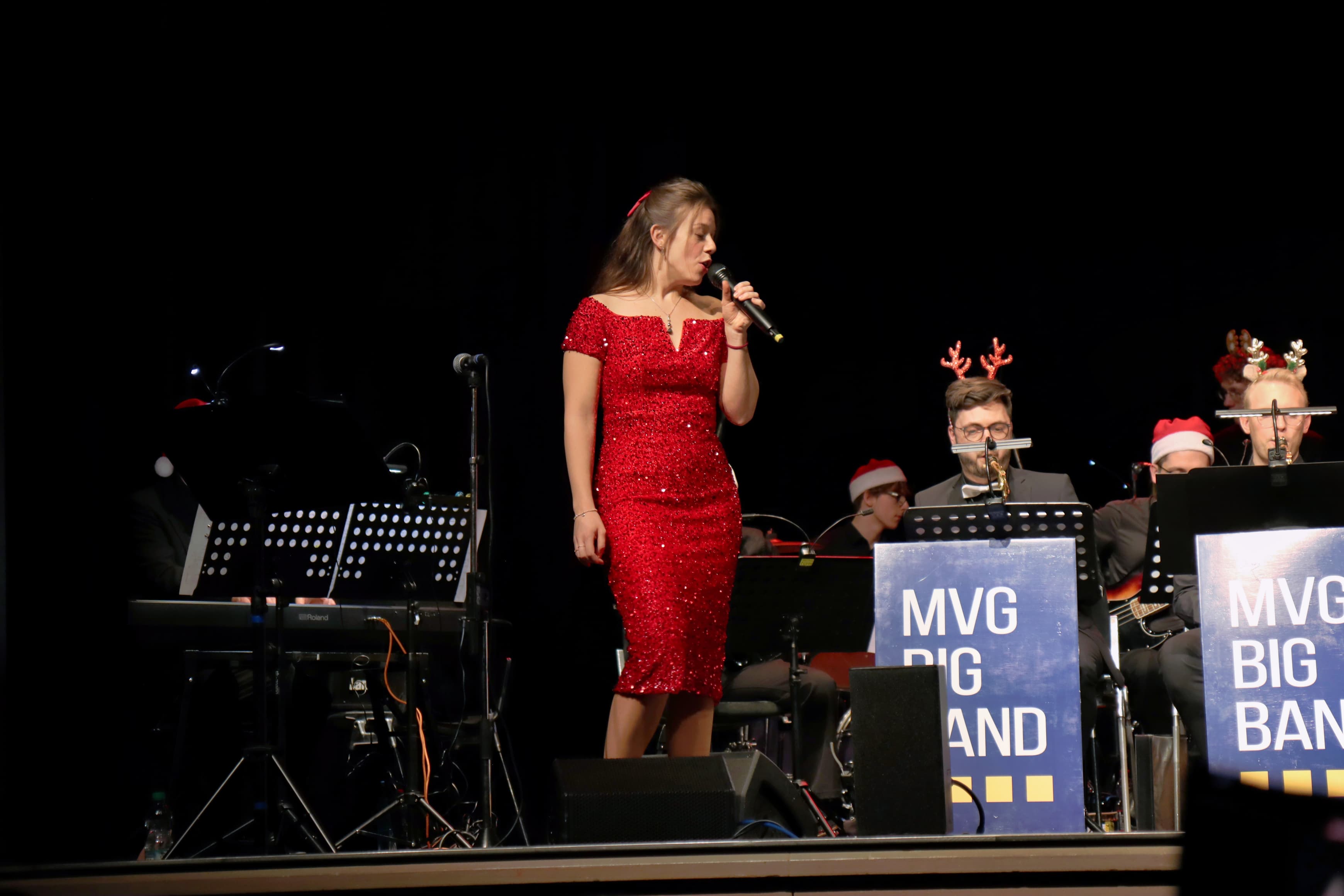 Pamela auf der Bühne in rotem Samtkleid vor einem Schlagzeug